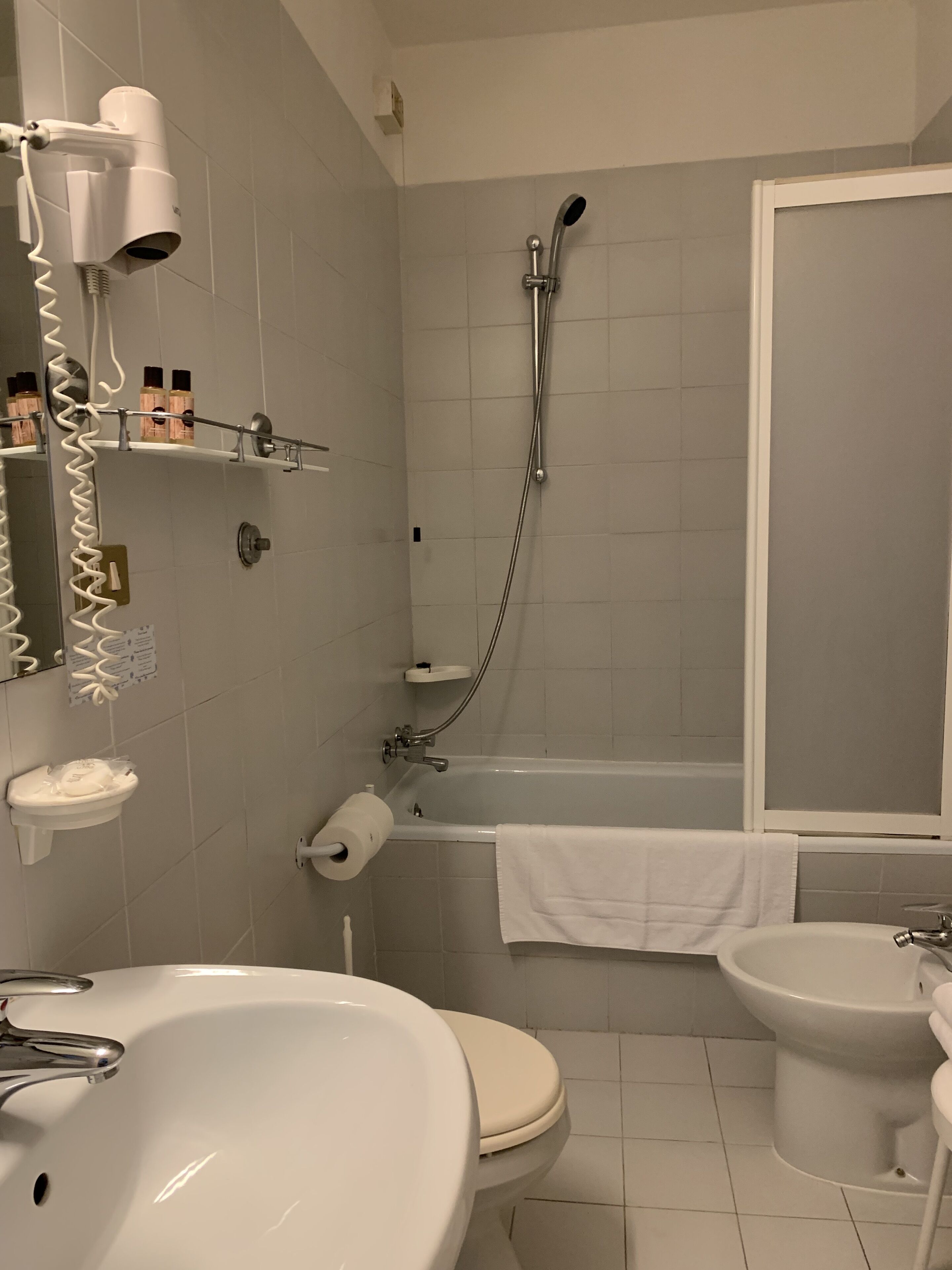 Ein Badezimmer mit Waschbecken, Toilette, Bidet und Dusche.