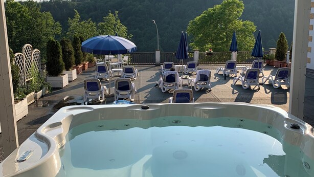 Un área de jacuzzi con vistas a una ladera boscosa.