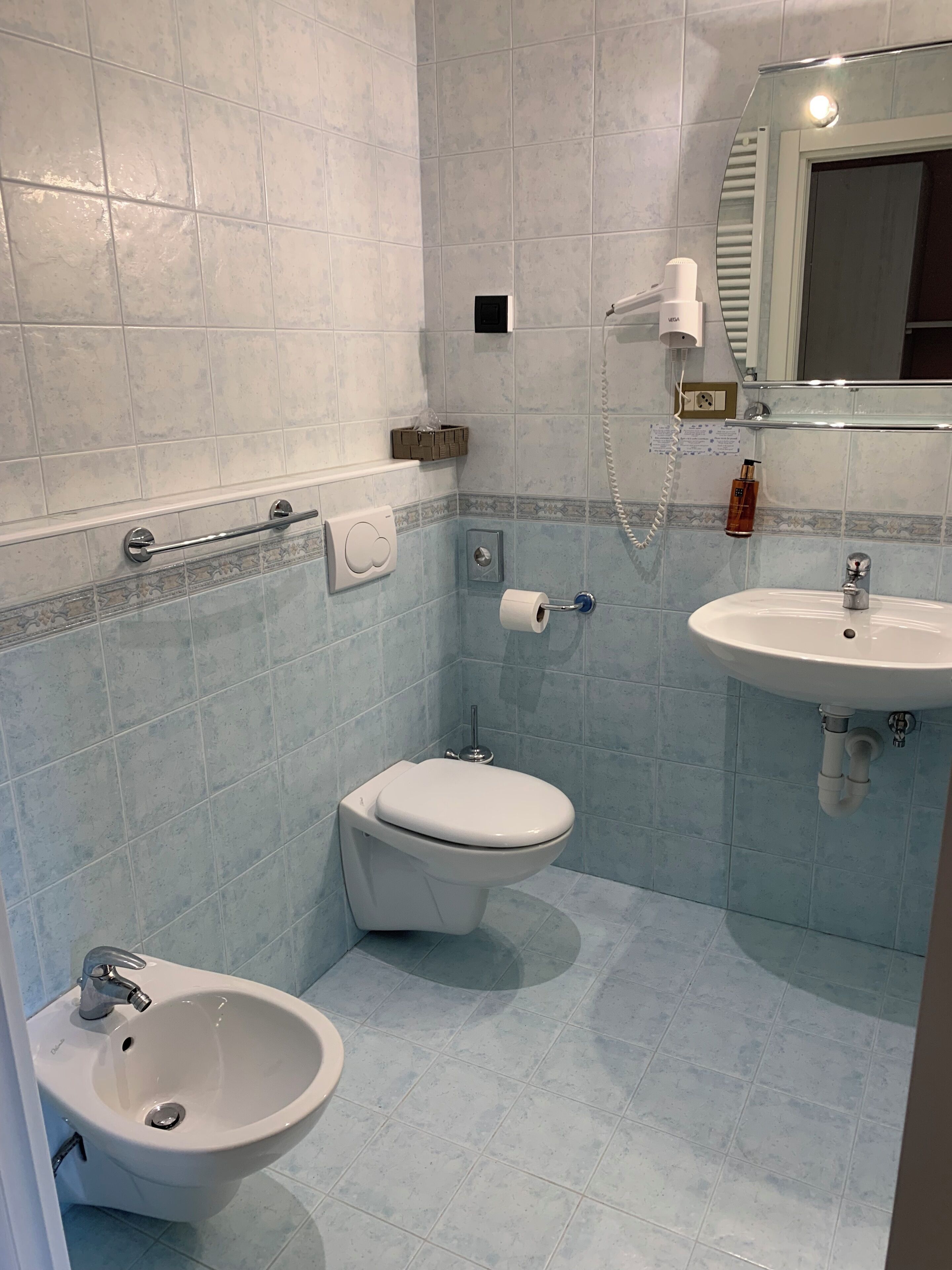 Un baño con inodoro, bidé y lavabo.