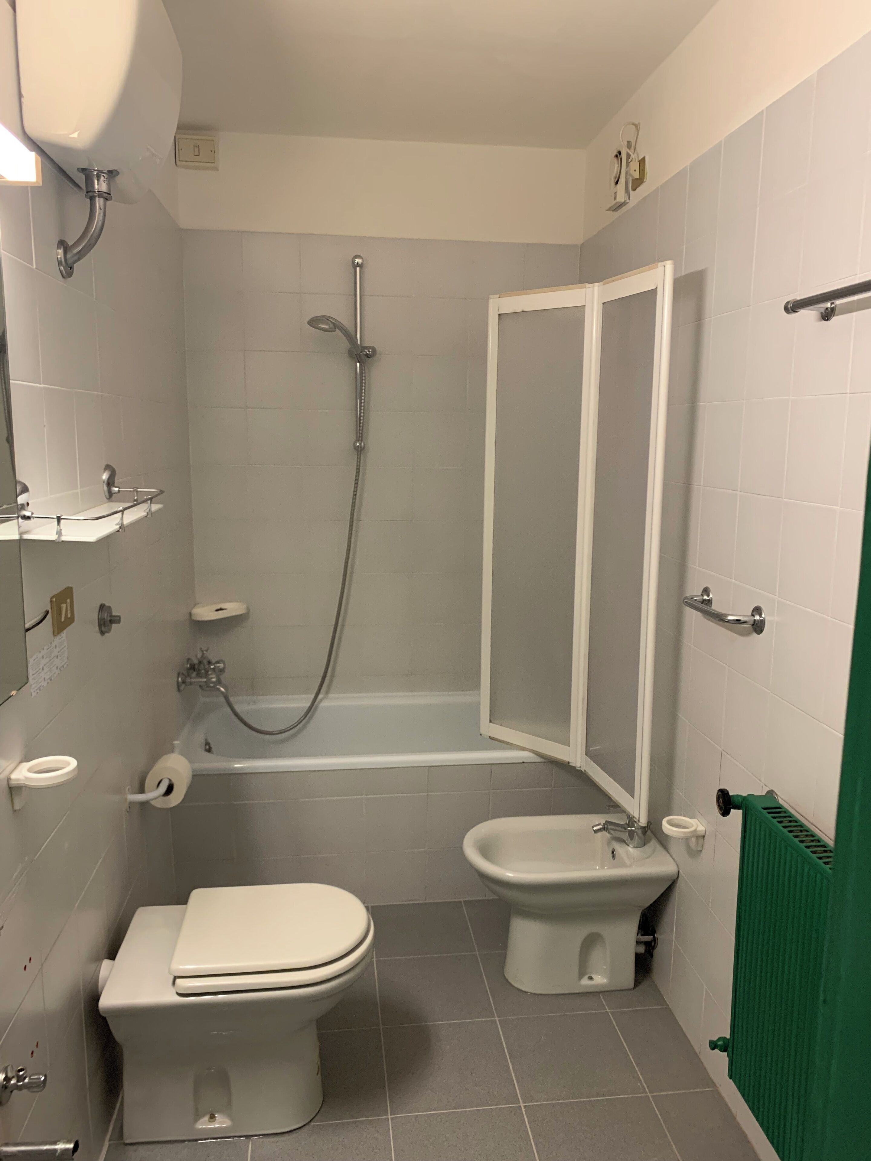 A bathroom with a toilet, bidet, and bathtub.