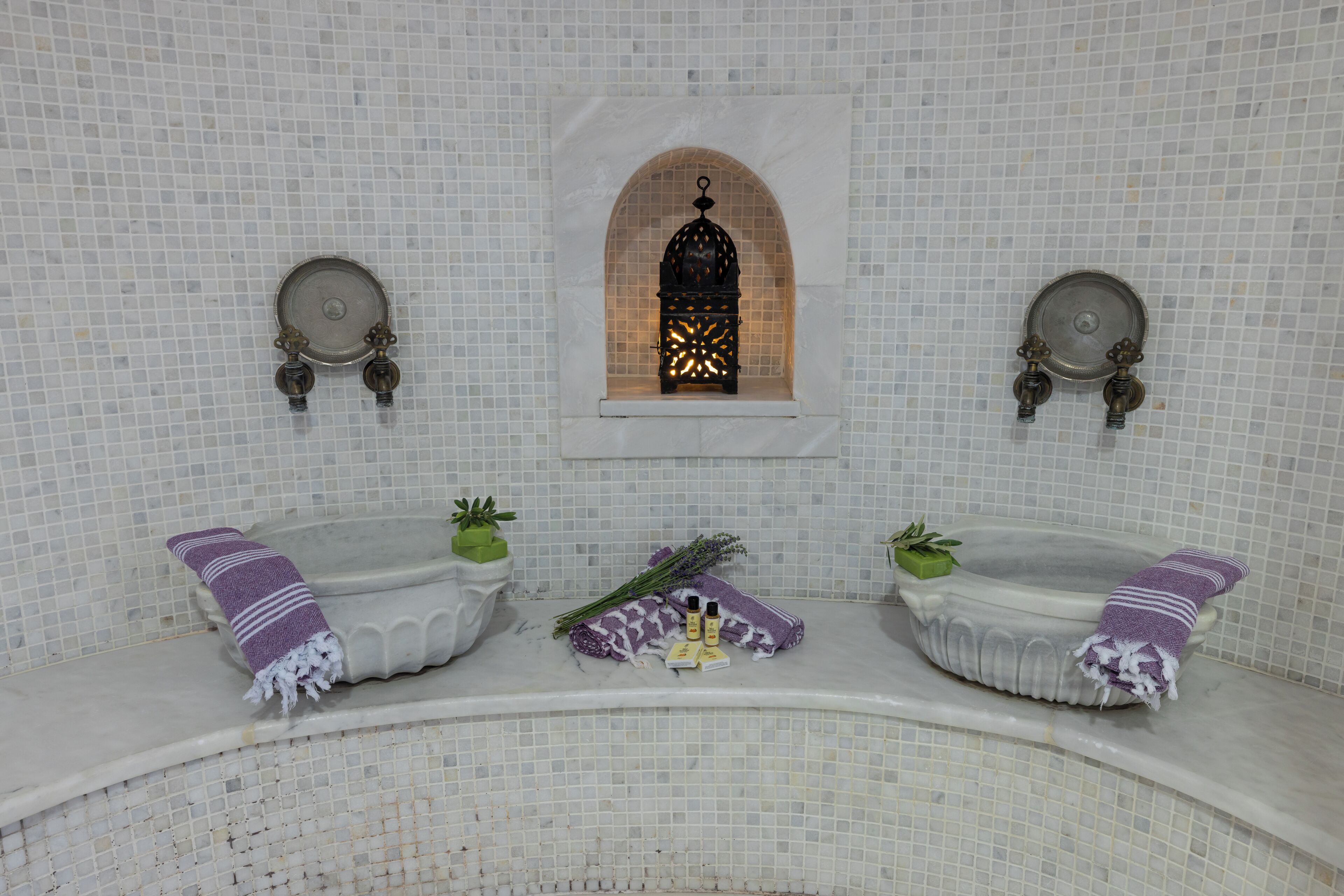 Un baño con dos lavamanos, una ventana y un detalle decorativo en la pared.