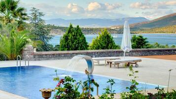 Una piscina al aire libre de temporada, sombrillas