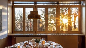A breakfast table set with various dishes and a view of trees through a window. - Casa das Penhas Douradas - Burel Expedition Hotel (Manteigas)