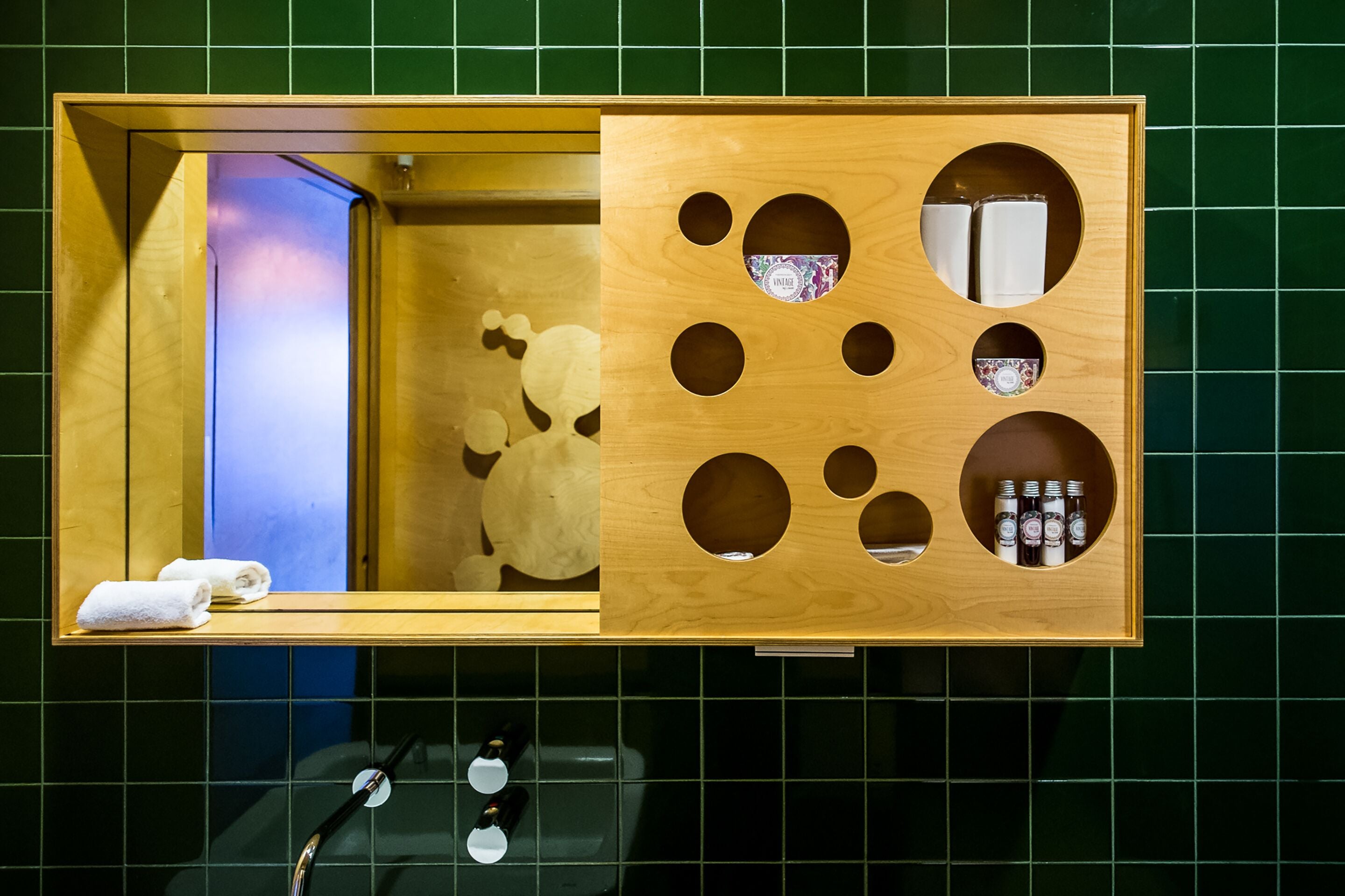 Un baño con tocador de madera, un espejo y una toalla sobre la encimera.