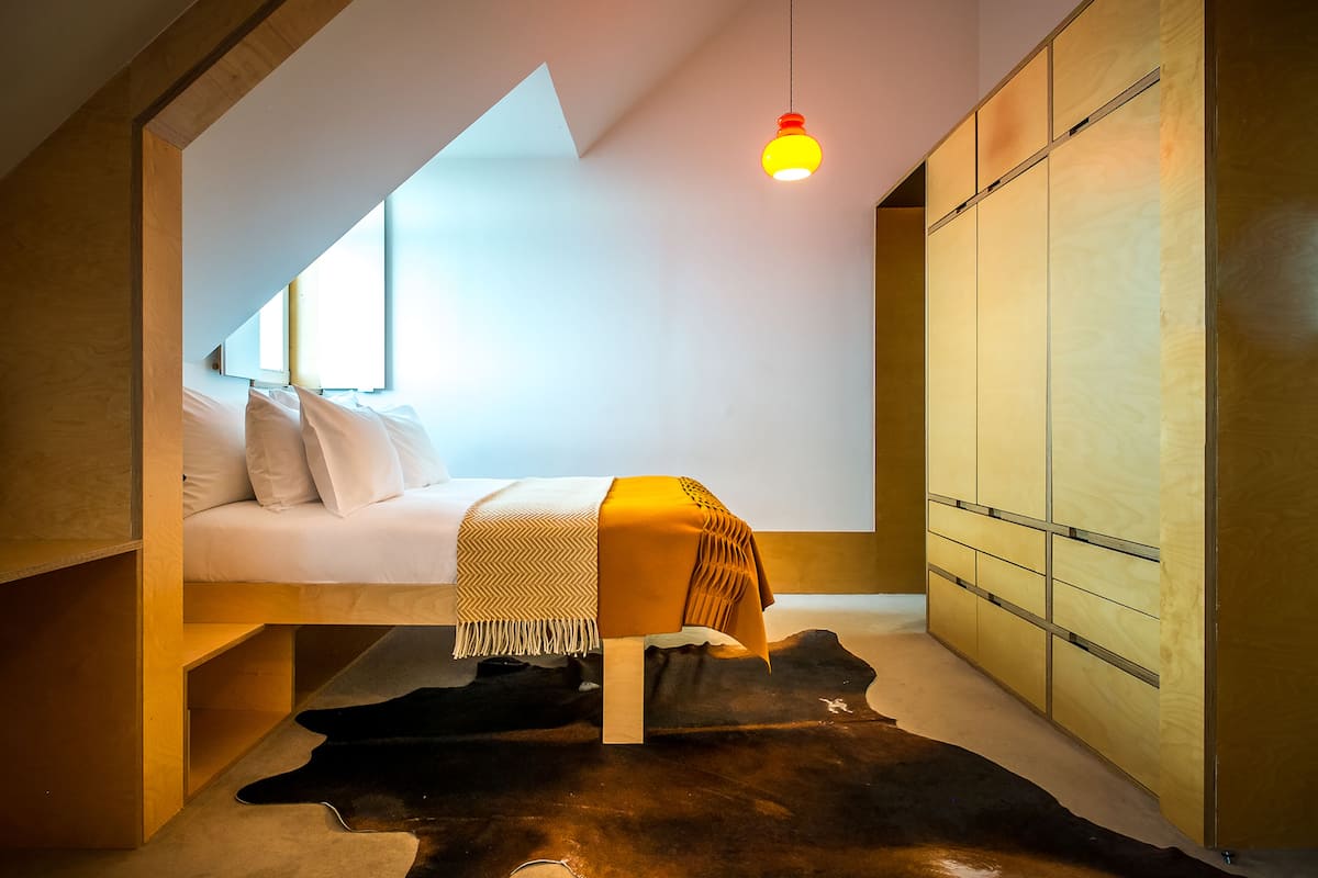 Ein Schlafzimmer mit einem Bett, einer Pendelleuchte und einem Kleiderschrank.