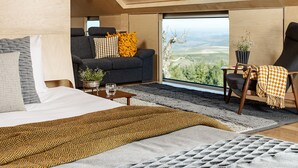 A modern room with a bed, sofa, and armchair, a large window with a view, and a skylight. - Casa das Penhas Douradas - Burel Expedition Hotel (Manteigas)