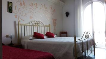 Un dormitorio con dos camas individuales, una mesita de noche con lámpara y un mural decorativo en la pared.