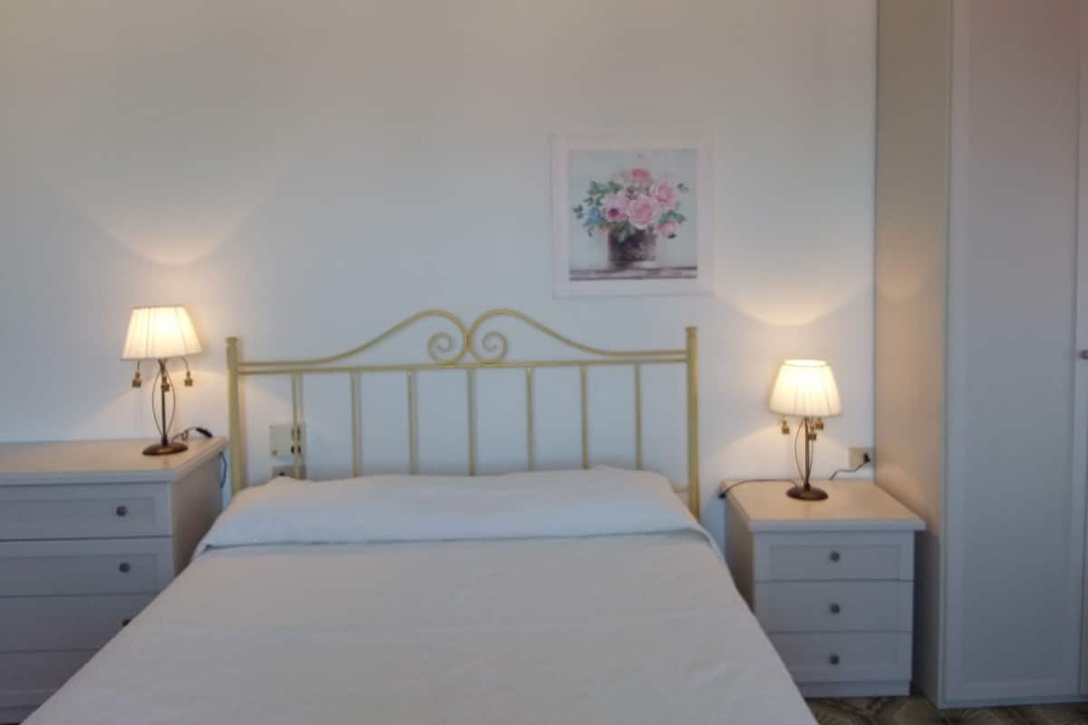 Desk, iron/ironing board, bed sheets