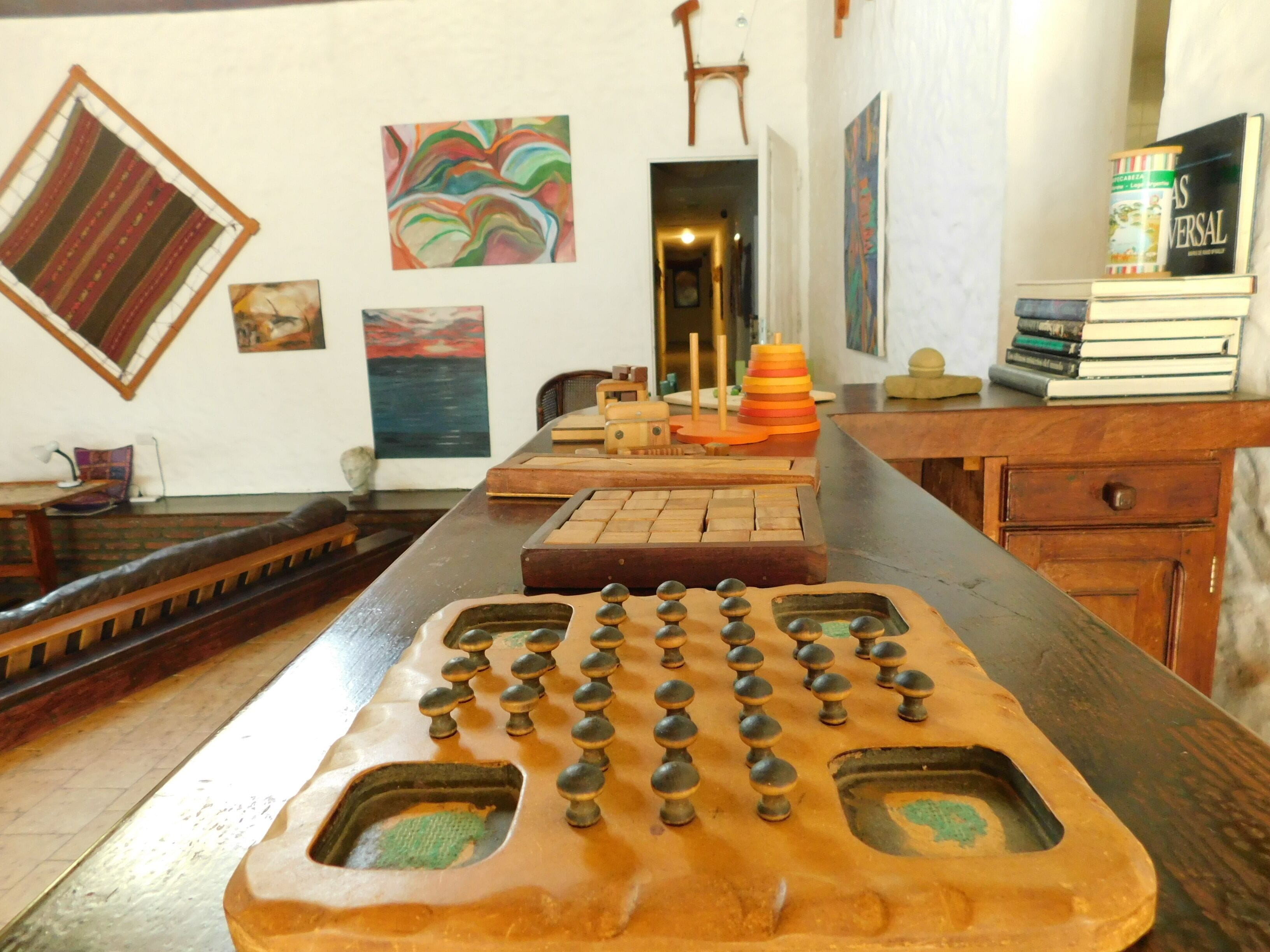 A wooden table with a board game, books, and decorative items.