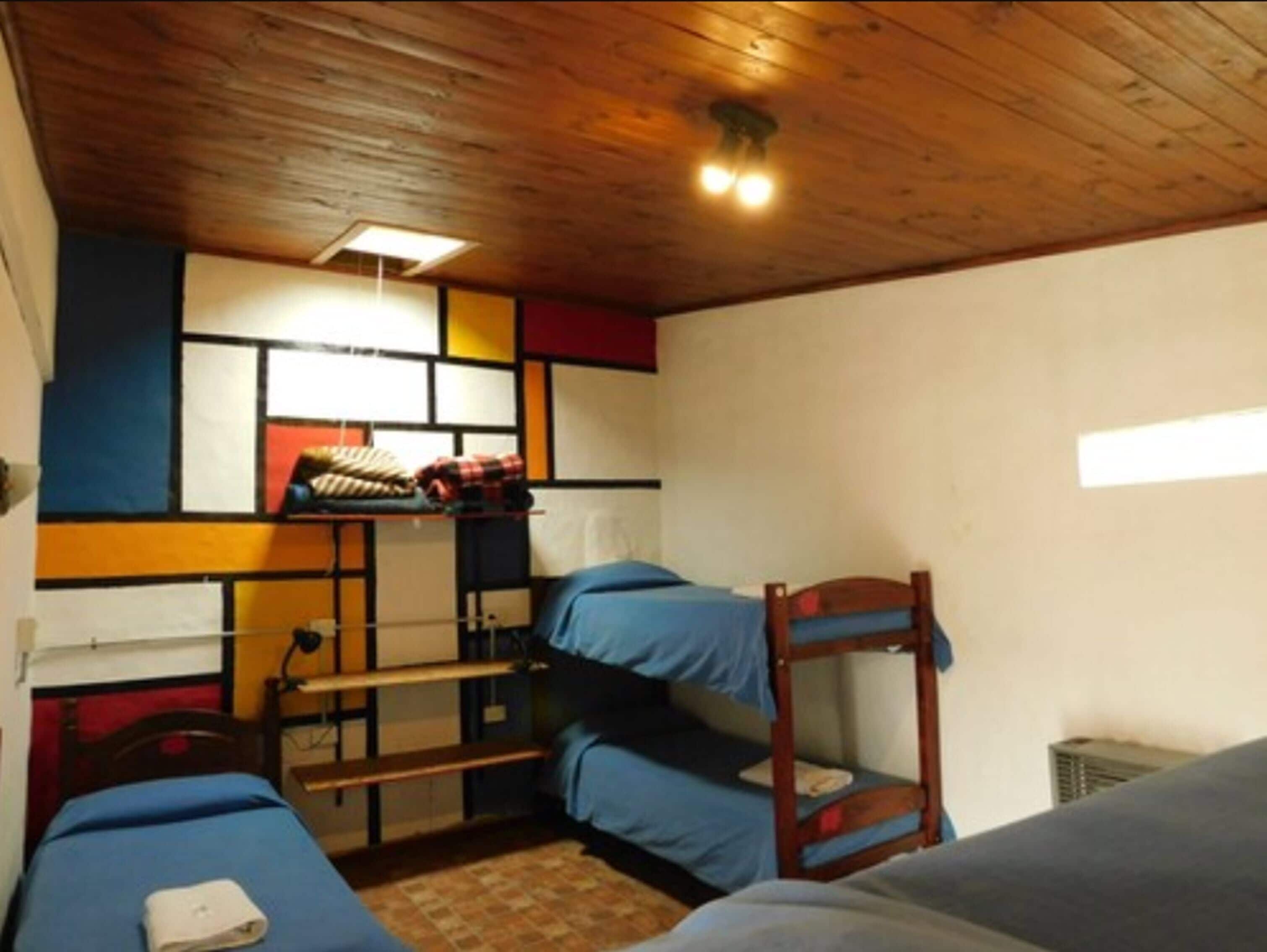 Un dormitorio con literas, un escritorio y una silla.