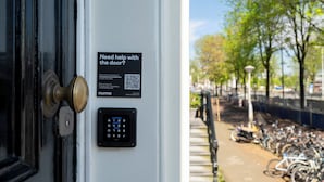 A door with a keypad and a sign offering help with the door. - Amsterdam Centre Harbour Apartments (Amsterdam)
