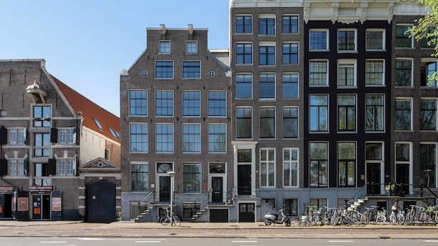 A row of multi-story buildings with uniform windows and a central entrance. - Amsterdam Centre Harbour Apartments (Amsterdam)