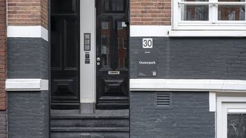 A black door with a number plate, a staircase, and a sign indicating the address as 30 Oosterpark.