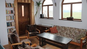 Une pièce chaleureuse avec une bibliothèque en bois, un canapé et une table.