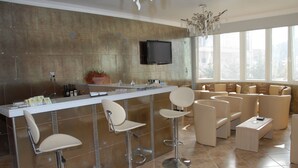 Eine moderne Küche mit Bar, Barhocker und einer Sitzecke mit Sofas.