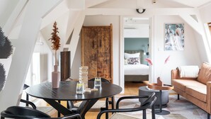 A modern loft bedroom with a large bed, a wooden door, and a view of the city. -  Numa Amsterdam Helmers (Amsterdam)