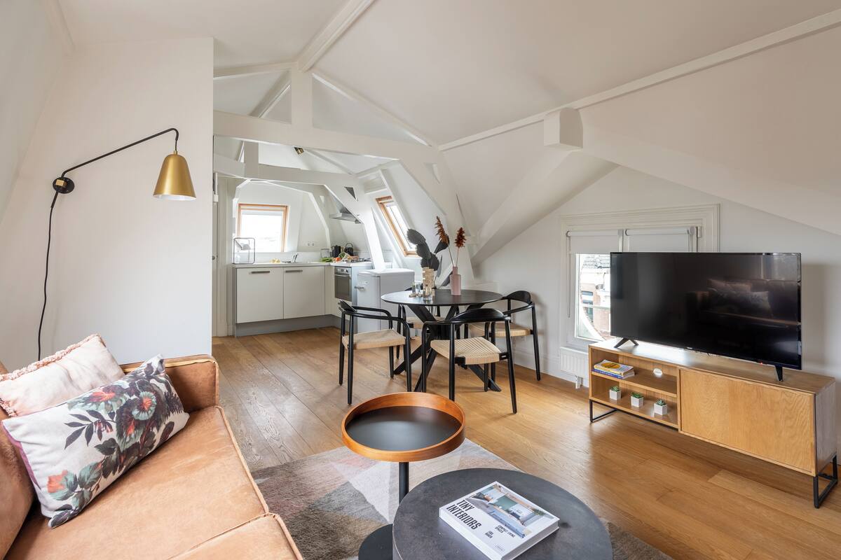 A modern loft apartment with a dining area, kitchen, and living space.
