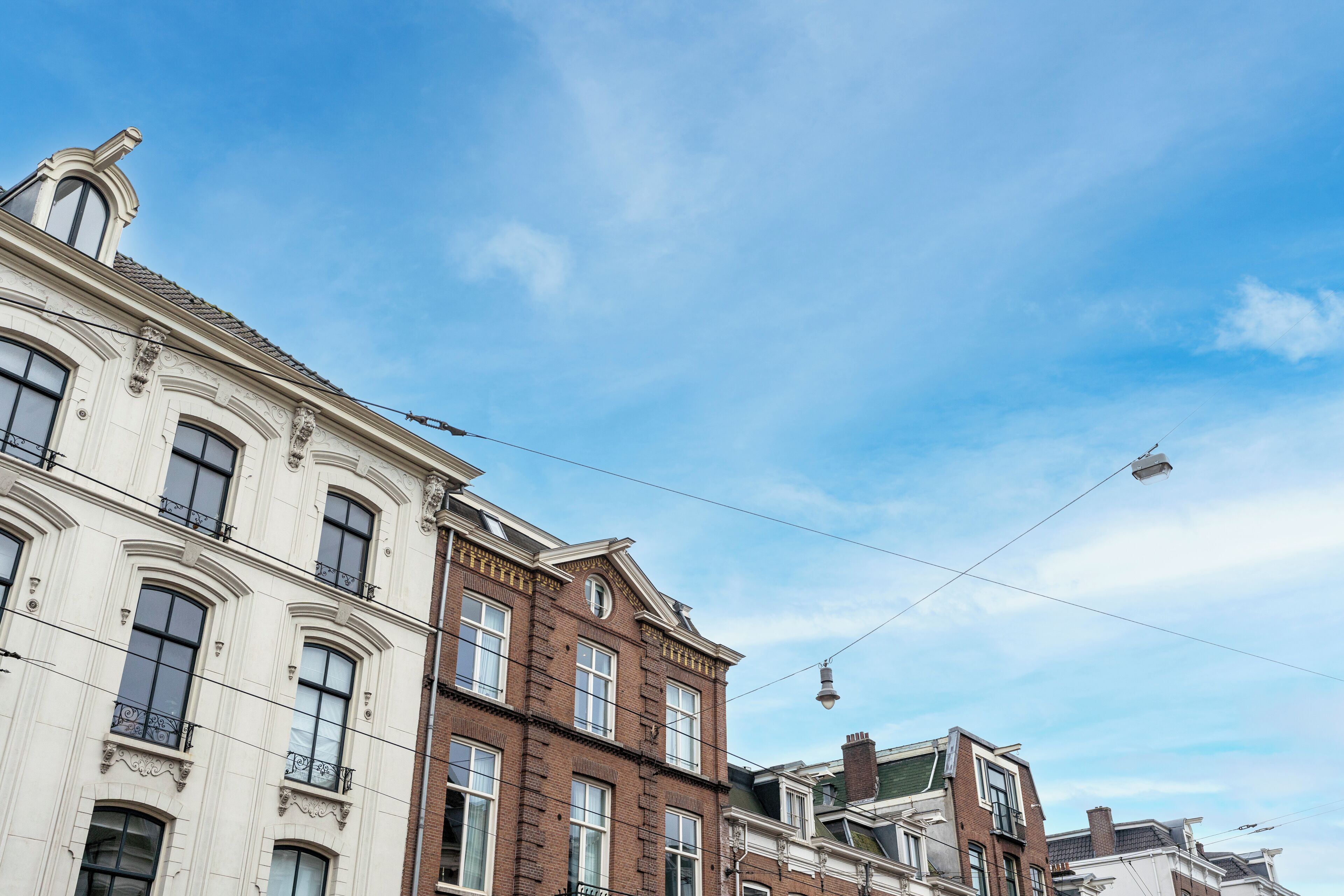 A row of historic buildings with classic architecture, including ornate window frames and detailed facades.