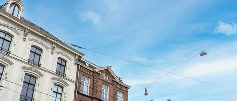 A row of historic buildings with classic architecture, including ornate window frames and detailed facades.