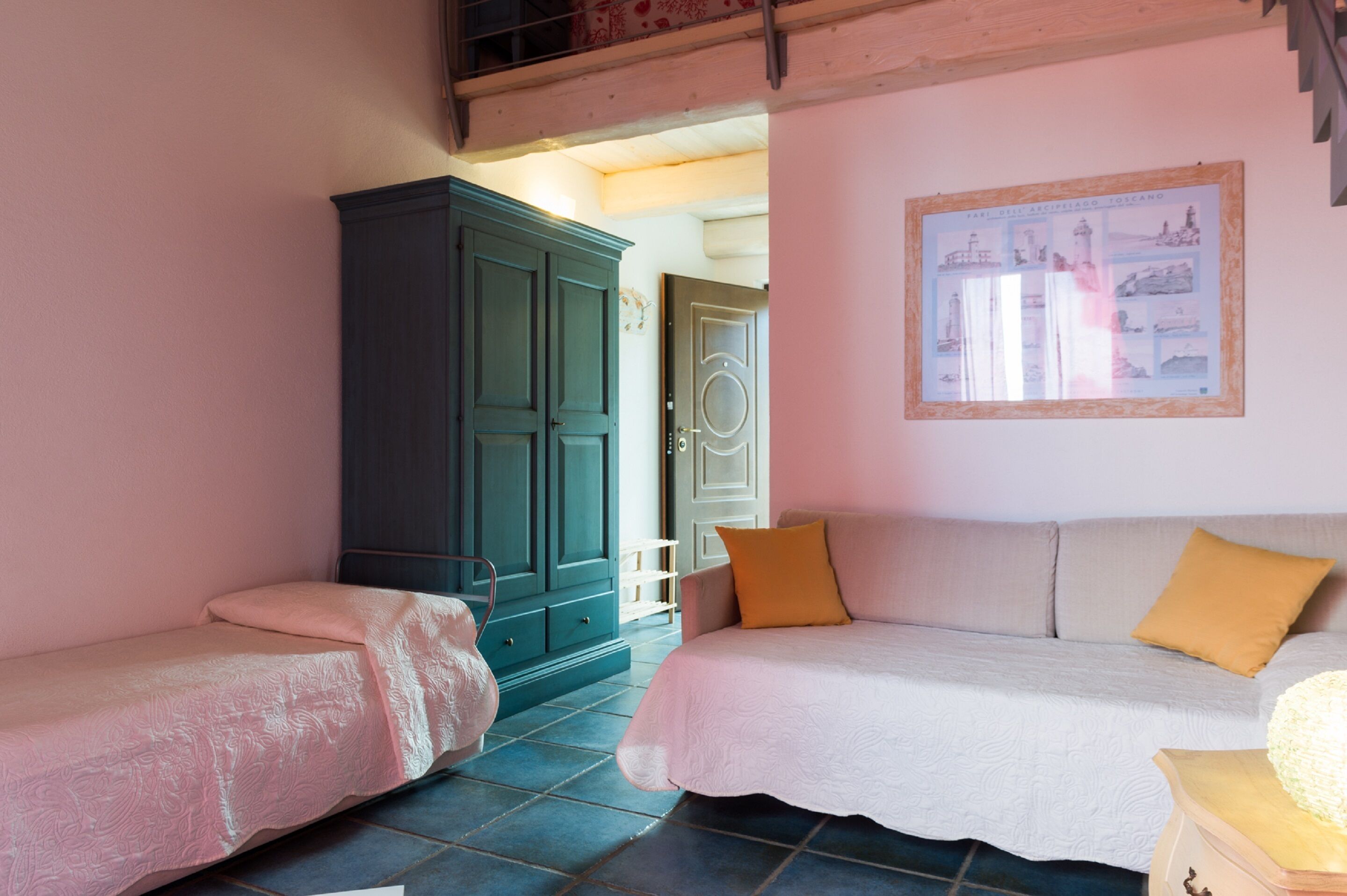 A bedroom with two single beds, a large wardrobe, and a framed picture on the wall.