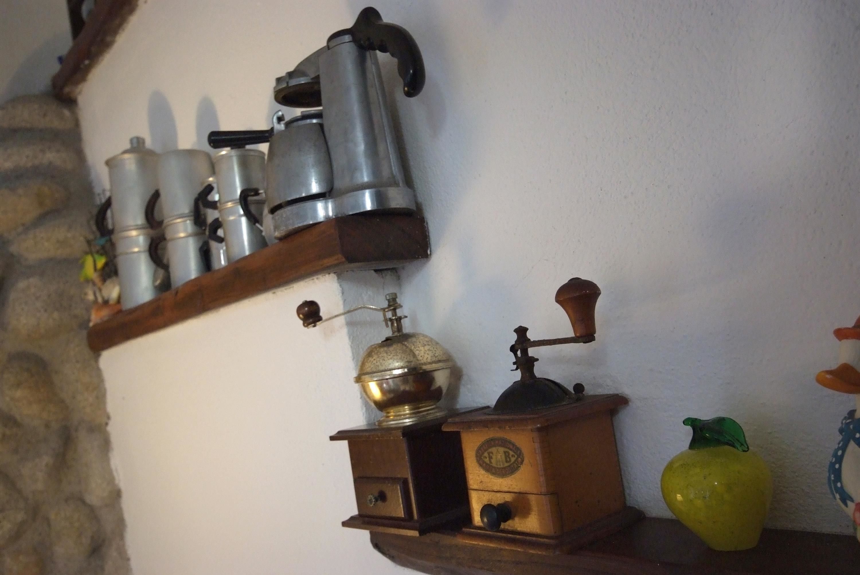 A kitchen shelf with various kitchen appliances and a decorative yellow pepper.