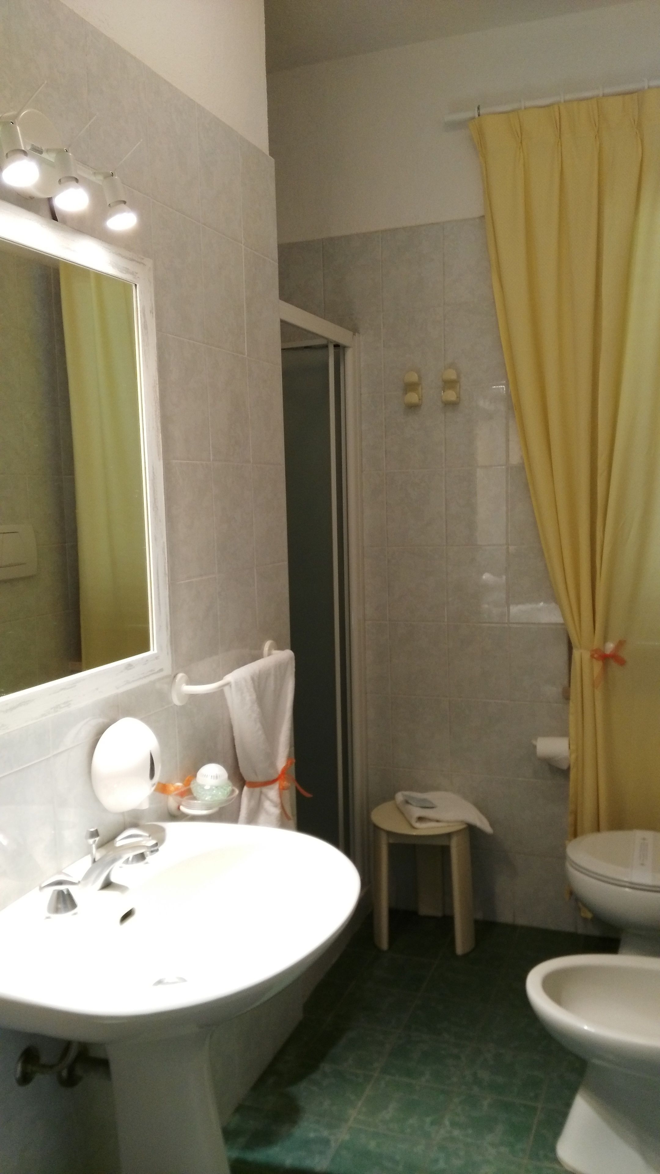 A bathroom with a sink, mirror, and two toilets.