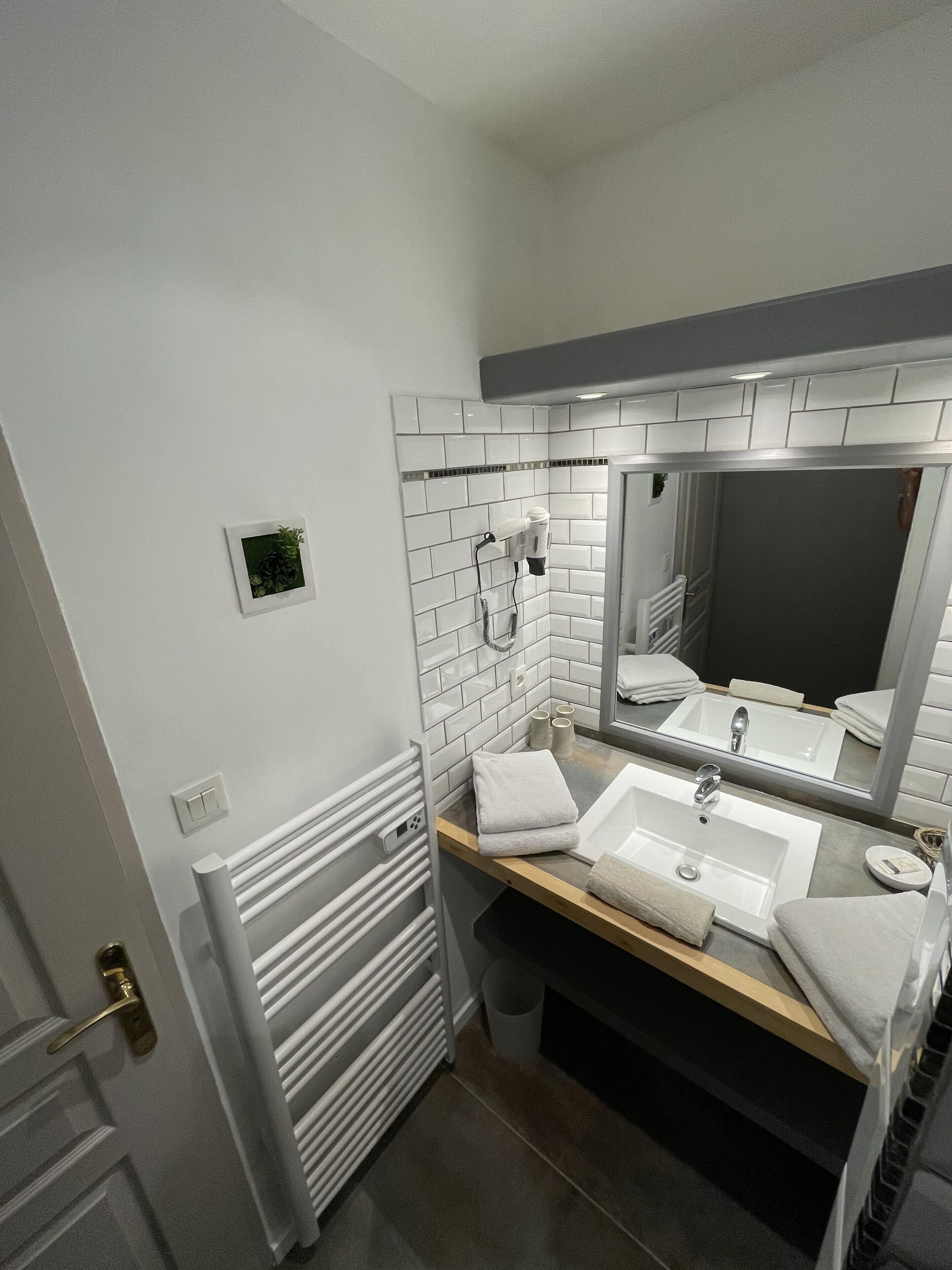 Un baño con dos lavamanos, un espejo y un perchero para toallas.