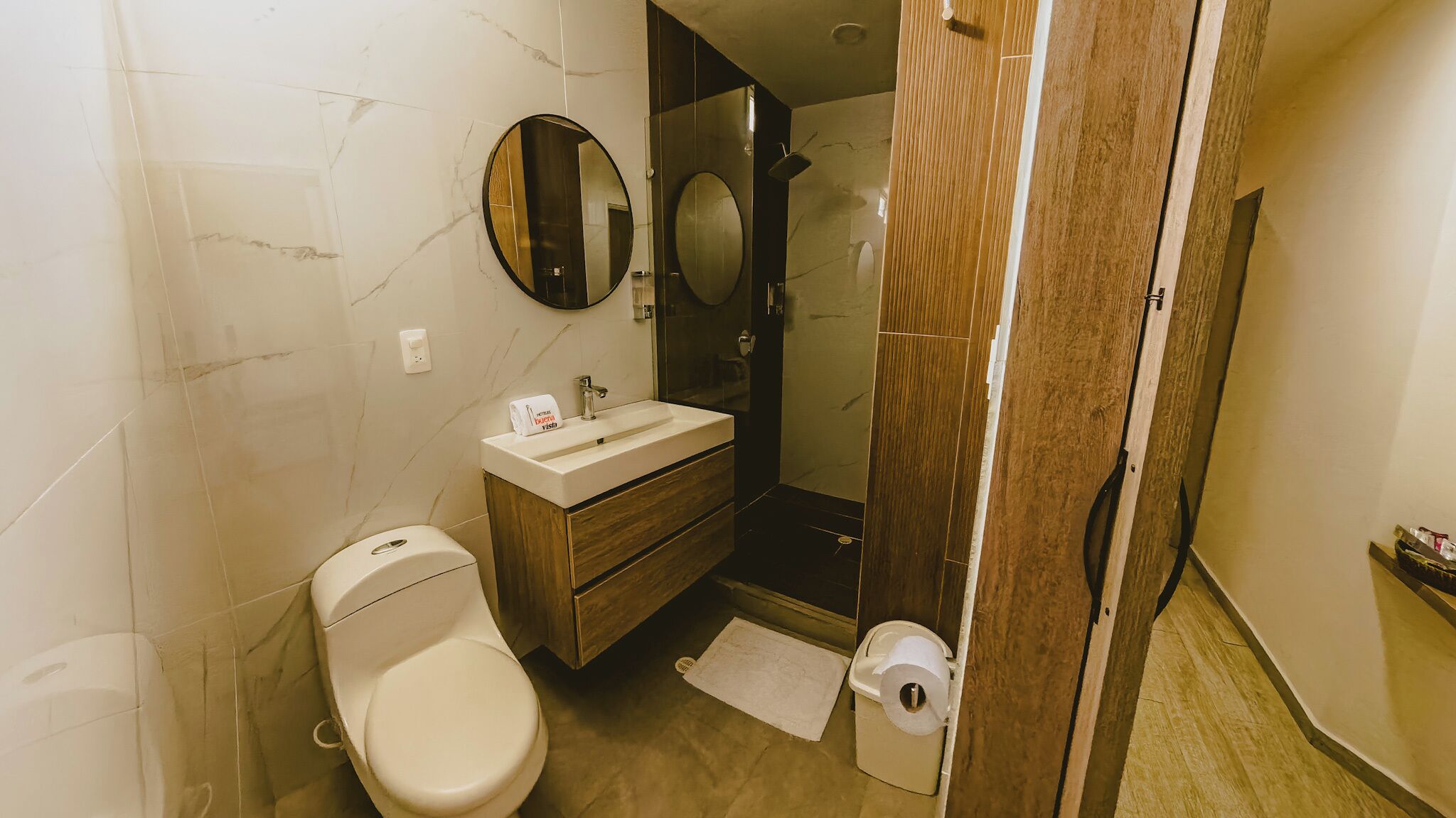A bathroom with a toilet, sink, and mirror.