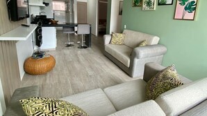 Una sala moderna con un sofá, un comedor y una cocina.