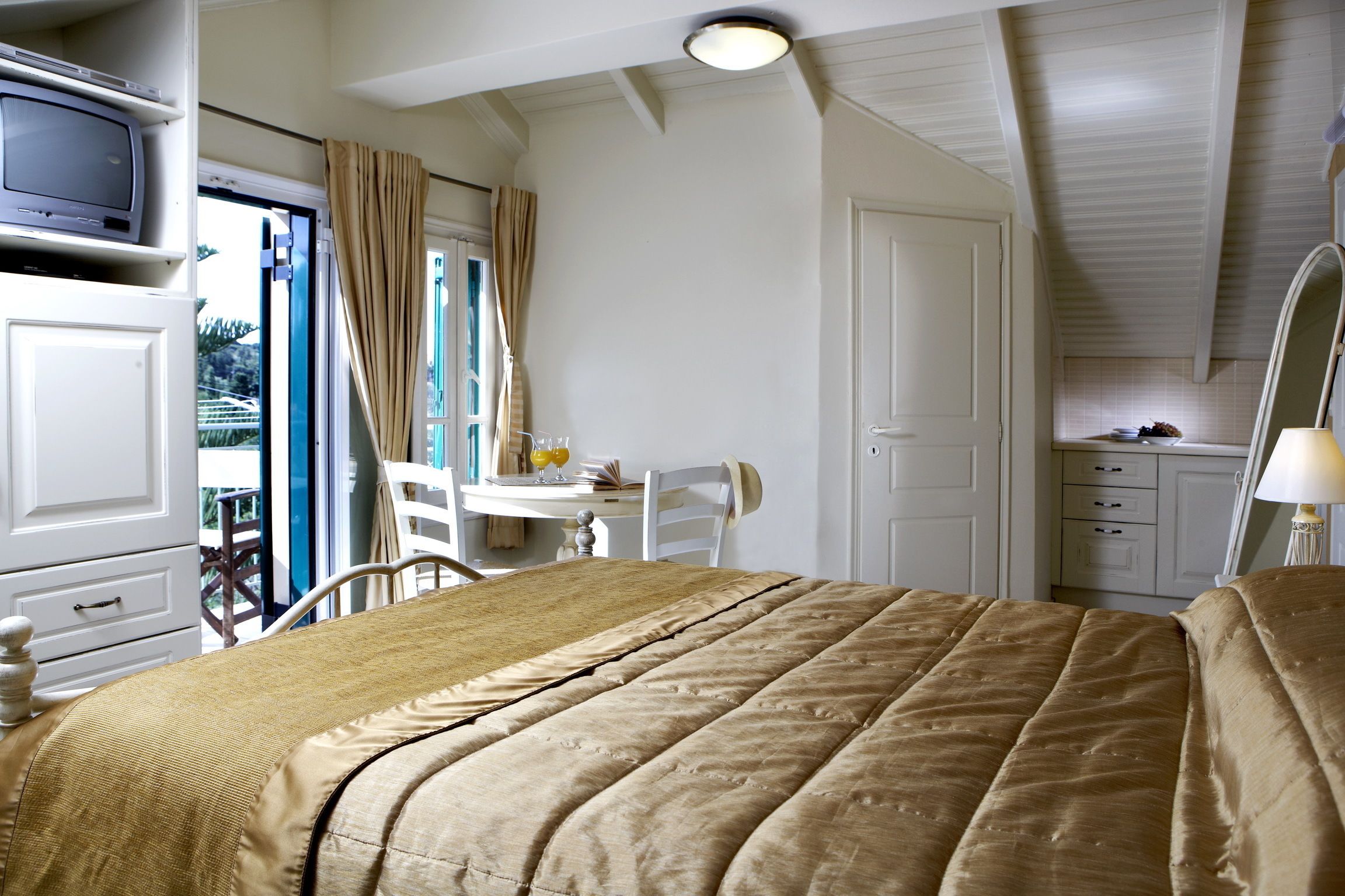 A bedroom with a bed, a desk, and a chair. There is a window with curtains, a door, and a ceiling light.