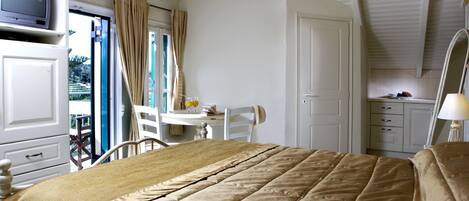 Une chambre à coucher avec un lit, un bureau et une chaise. Il y a une fenêtre avec des rideaux, une porte et un luminaire au plafond.