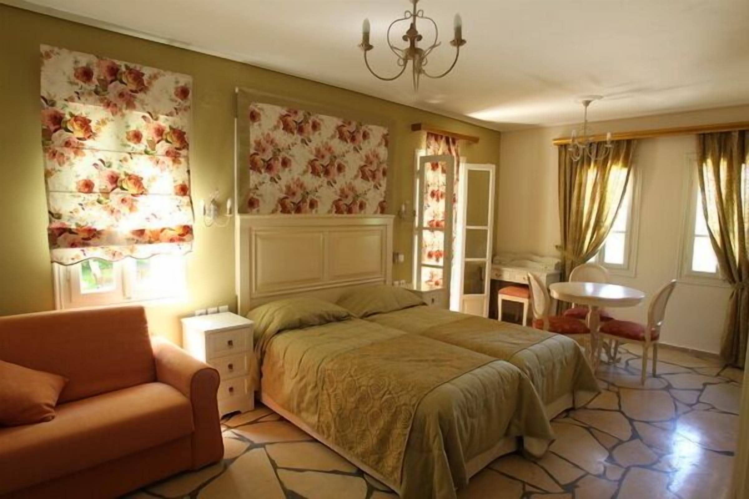 Quarto com cama, cadeira, escrivaninha e lustre.