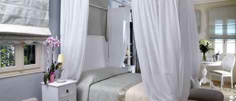 Une chambre à coucher avec un lit à baldaquin, une table de chevet avec une lampe et une chaise.
