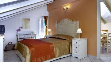 A bedroom with a bed, bedside tables, a dresser, a mirror, and a window with curtains.