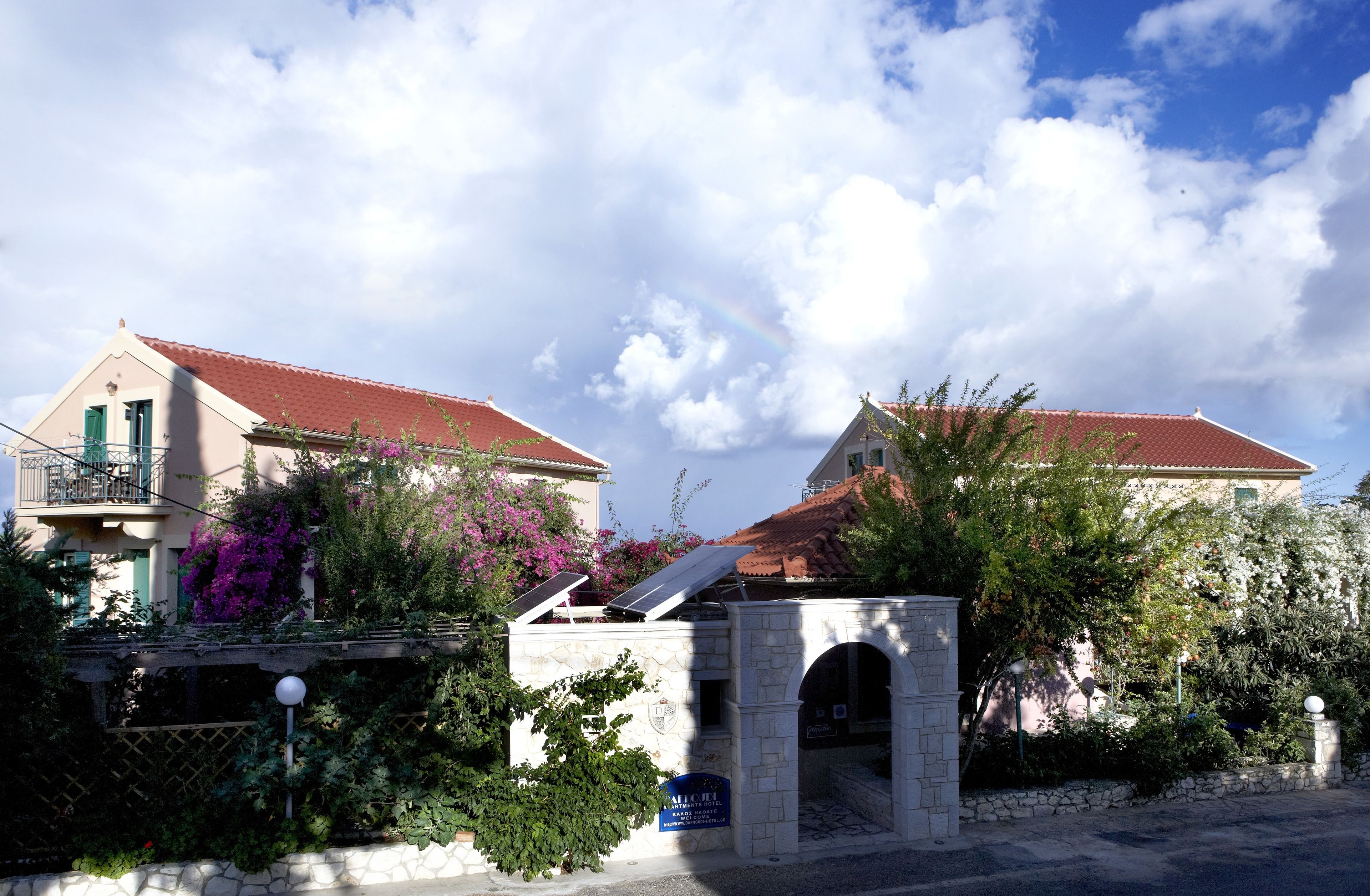 A building with a red-tiled roof, a stone archway, and a sign indicating it is a hotel.