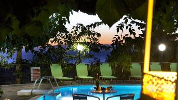 Alberca al aire libre, sombrillas en la alberca y camastros