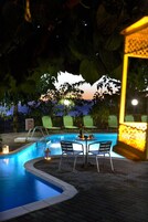 Una piscina al aire libre, sombrillas, tumbonas