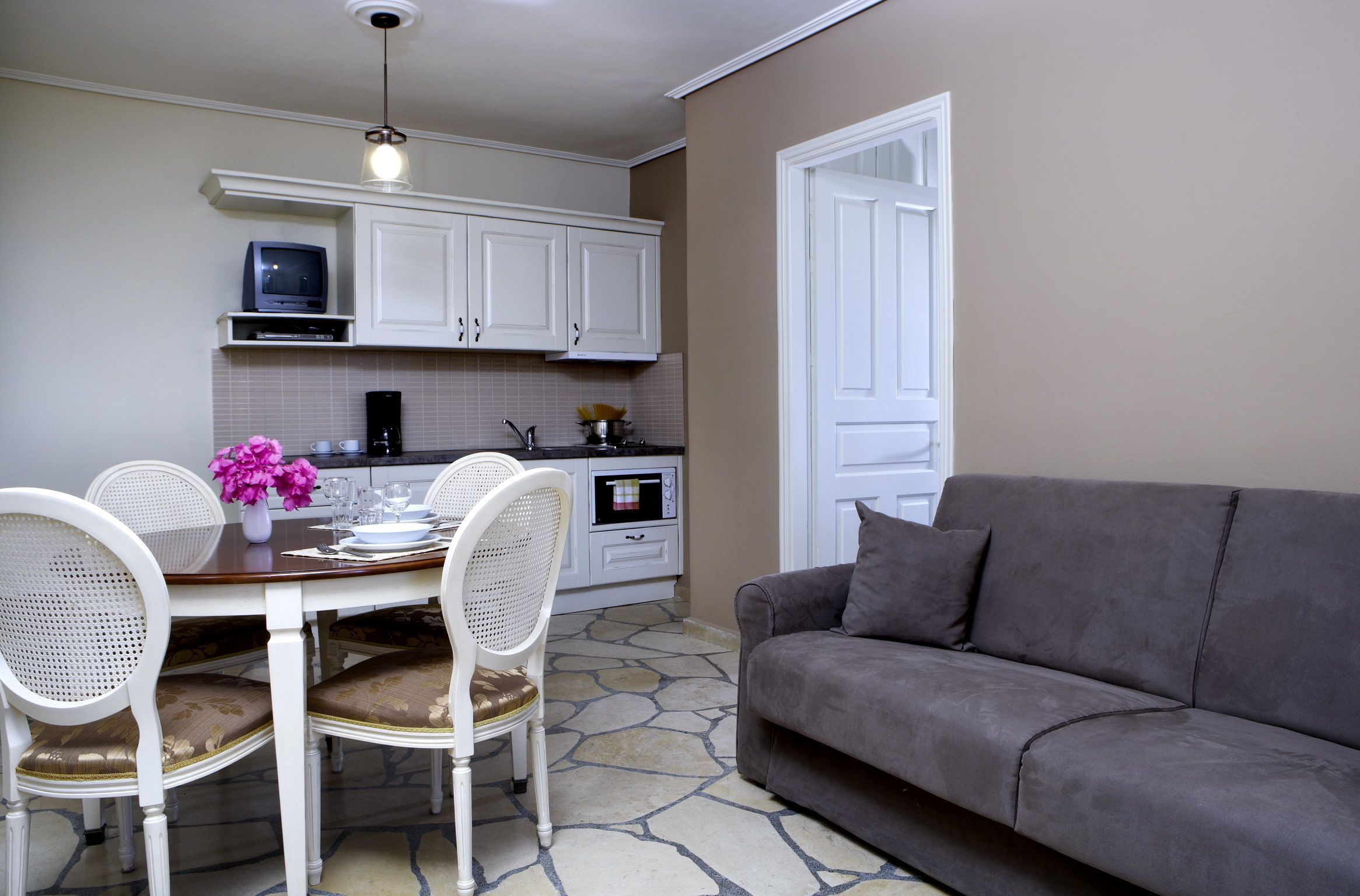 A compact living space with a dining area, kitchenette, and a sofa.