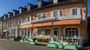 Ein Hotel mit Bar und Restaurant im Erdgeschoss, Außenbereich und einem Schild, das ein Restaurant mit P.M.U. kennzeichnet.