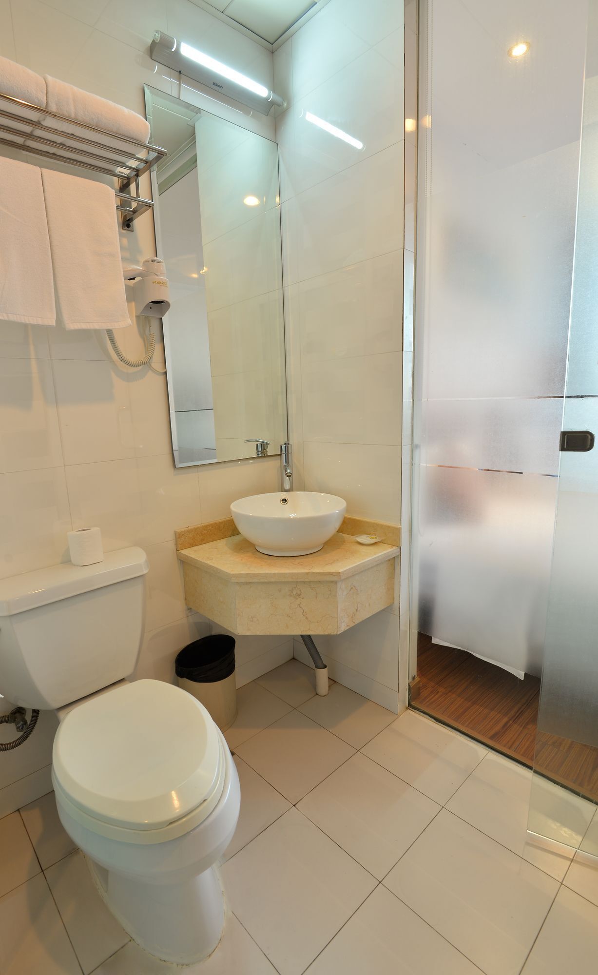 A modern bathroom with a toilet, sink, and mirror.