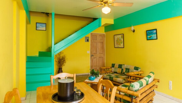 Un espace repas comprenant une table en bois, des chaises et un ventilateur de plafond.