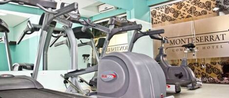 A gym with various exercise equipment, including treadmills and elliptical machines.