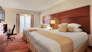 Een hotelkamer met twee bedden, een bureau en een televisie.