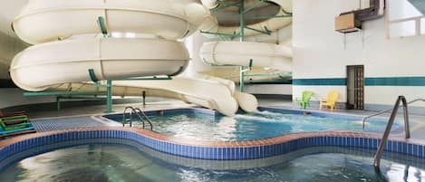Una piscina techada, sillones reclinables de piscina