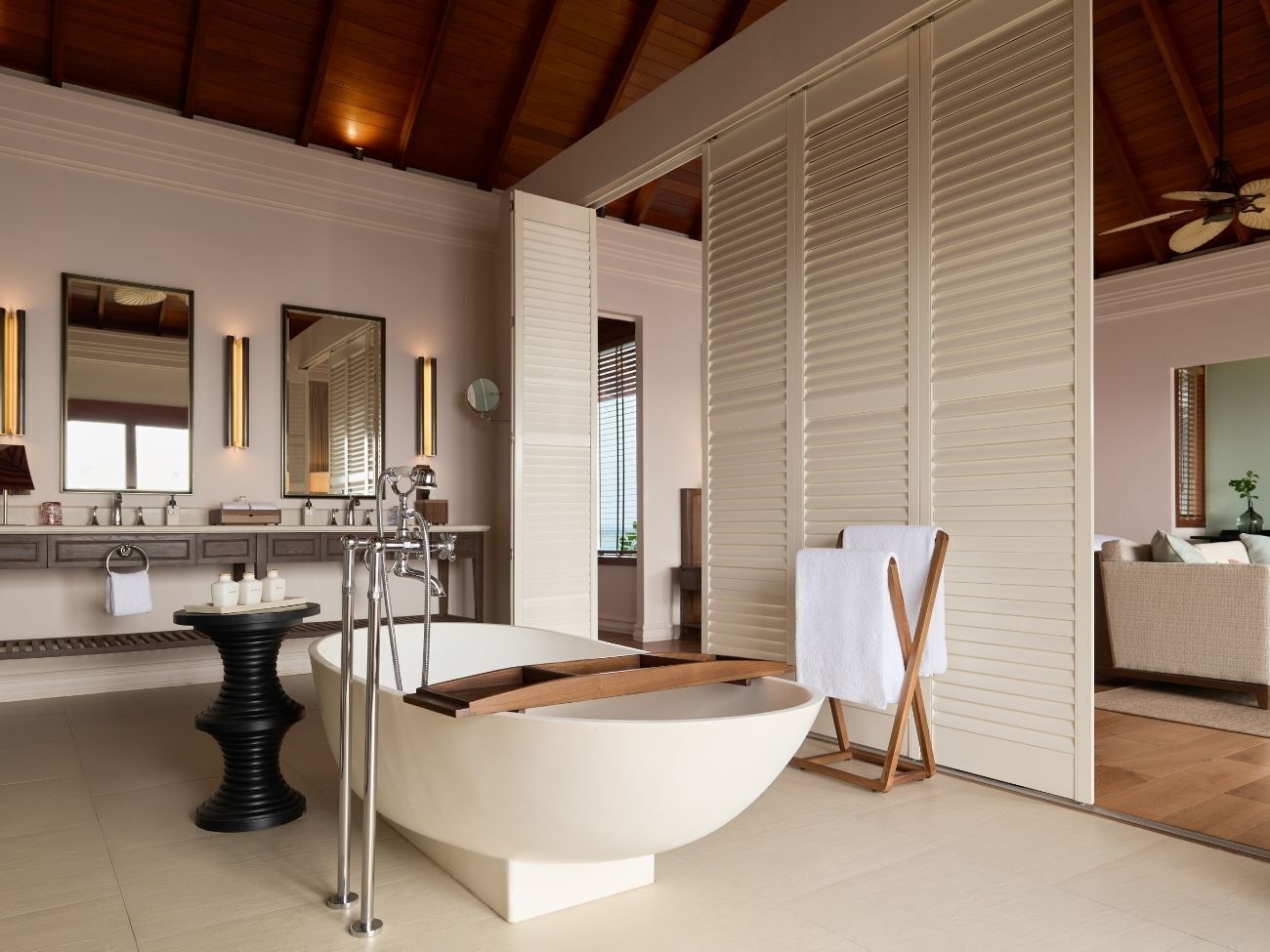 A modern bathroom with a freestanding bathtub, a vanity with a mirror, and a towel rack.
