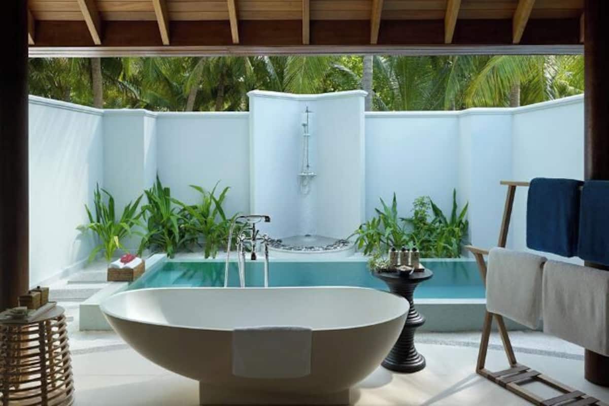 Una piscina al aire libre, sombrillas, sillones reclinables de piscina