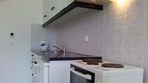 A compact kitchen with a stove, oven, and sink. - Liberatos Village (Kefalonia)