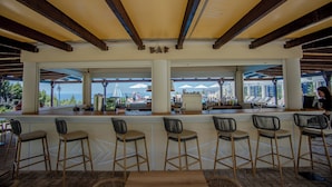 An outdoor bar area with wooden beams and a view of the sea. - Liberatos Village (Kefalonia)