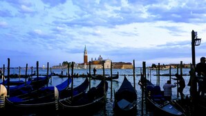 Gondolas docked at a pier with a historic building in the background. - Ecogarden (Mestre)