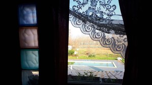 A window with a view of a swimming pool and a fence. - Ecogarden (Mestre)